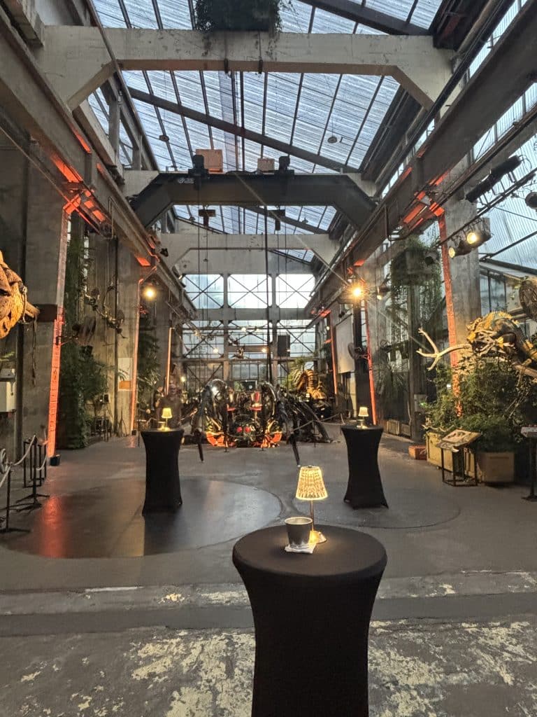 Perspective de la grande nef industrielle illuminée en orange pour un cocktail d'entreprise à Nantes.