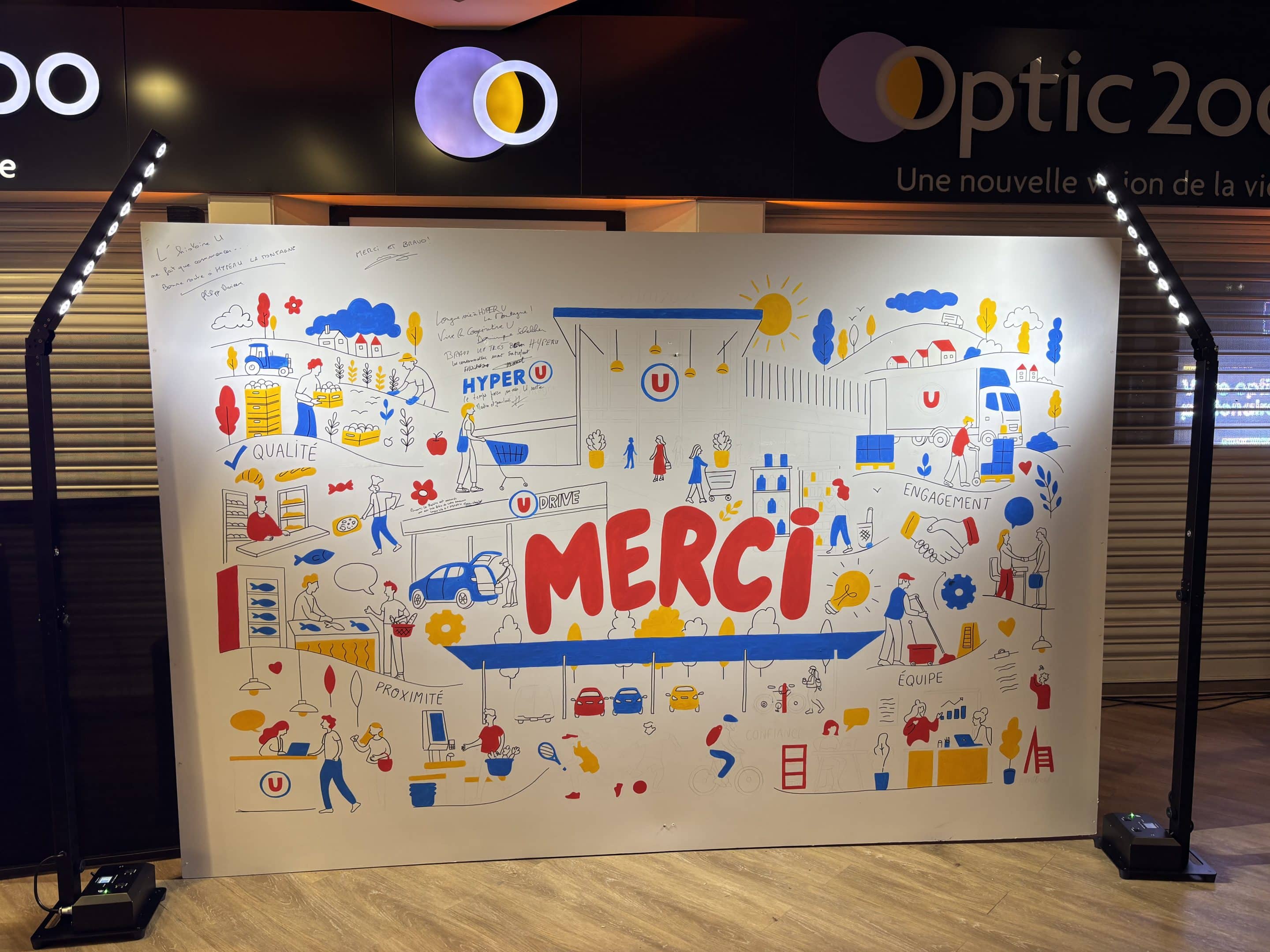 Mâts de projecteurs télescopiques sans fil éclairant un grand mur d'animation commerciale pour la marque Hyper U.