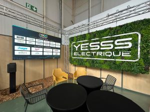 Écran panoramique LED suspendu sur structure truss affichant les marques partenaires au-dessus d'un espace lounge.